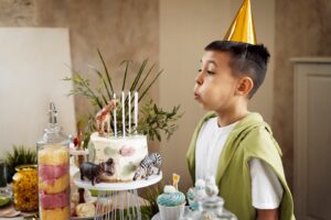 Ребенок задувает свечи на торте